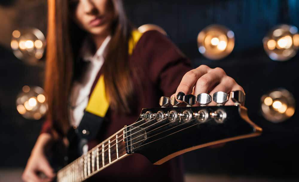 Girl tuning a guitar