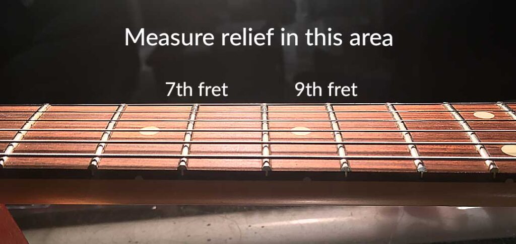 Measure neck relief in the 7th to 9th fret area